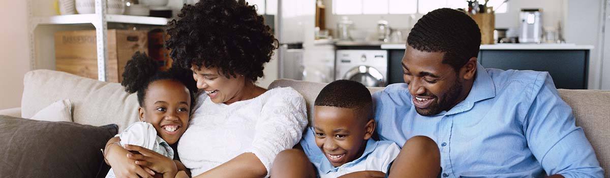 cute family of 4 sitting on couch